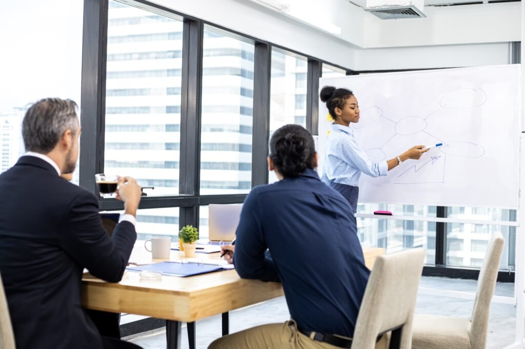 Woman offering information on board to team.